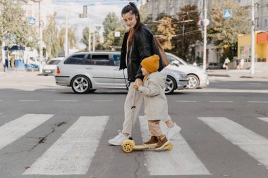 14.09.2020 Vinnitsa, Ukrayna: anne yaya geçidinde scooter süren bir çocuk getiriyor 