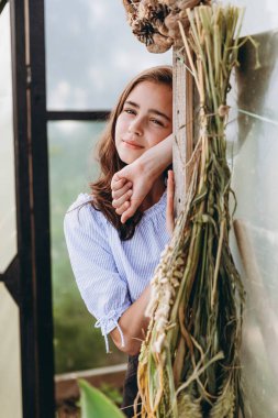 Çiçek tarlasında mutlu bir şekilde bir sepet çiçek taşıyan 13 yaşında tatlı bir kız çocuğu.