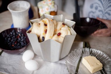 Çörek için kuru üzümlü maya hamuru ya da içinde malzemeler olan bir fırın tabağında paskalya pastası. Bayramlık Paskalya pastaları yapma süreci