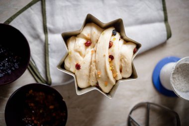 Çörek için kuru üzümlü maya hamuru ya da içinde malzemeler olan bir fırın tabağında paskalya pastası. Bayramlık Paskalya pastaları yapma süreci
