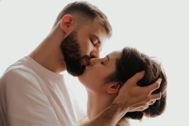 Genç ve mutlu bir adamın güzel bir kadını öpüp kucaklaması.