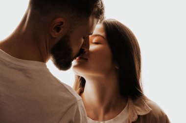 Genç ve mutlu bir adamın güzel bir kadını öpüp kucaklaması.