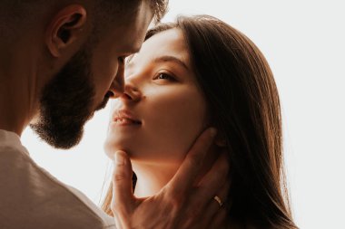 Genç ve mutlu bir adamın güzel bir kadını öpüp kucaklaması.