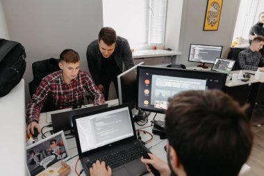 19.03.2021 Vinnitsa, Ukrayna: küçük bir yazılım şirketi için çalışan iki genç adam. Çalışanlar, ofisteki bilgisayar işleriyle meşguller.