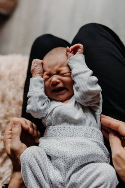 Annesinin kollarında yeni doğmuş bir bebeğin ev fotoğrafları. Seçici odak, gürültü etkisi