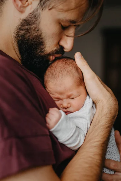 Yeni doğmuş bir bebeğin babasının kollarında çekilmiş fotoğrafları. Seçici odak, gürültü etkisi