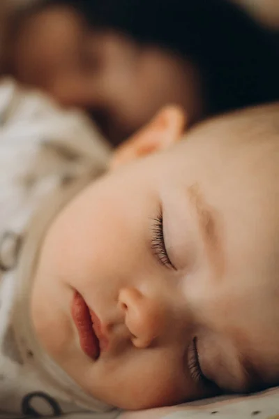 選択的焦点雑音効果 母親の隣のベッドで一日中寝ていた赤ん坊の肖像画 — ストック写真