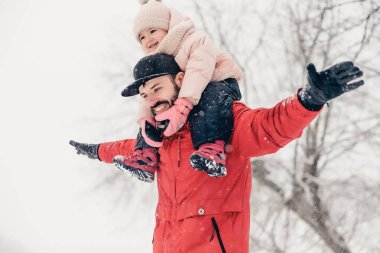 Sevgi dolu bir aile! Babası ve bebeği dışarıda oynuyorlar ve sarılıyorlar. Küçük çocuk ve babası karlı bir kış yürüyüşünde. Uzun zamandır beklenen ilk kar yağışının konsepti. Boşluğu kopyala