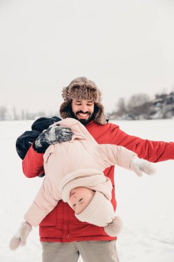 Yakışıklı sakallı genç baba ve küçük tatlı kızı kışın dışarıda eğleniyorlar. Birlikte vakit geçirmenin tadını çıkarıyorum. Aile kavramı