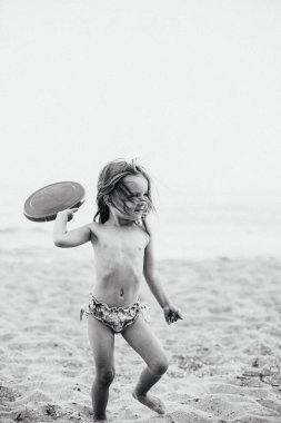 Okyanus kenarında oynayan ve eğlenen bir kızın portresi.