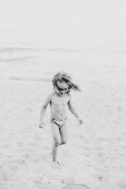Okyanus kenarında oynayan ve eğlenen bir kızın portresi.