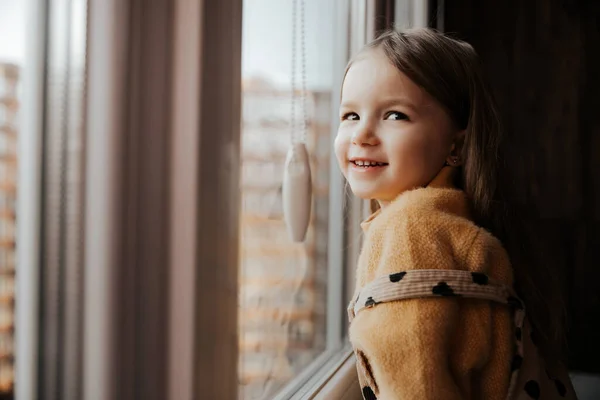 Liten Flicka Fönsterbrädan Tittar Genom Fönstret Från Lägenheten Höghus — Stockfoto