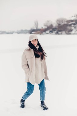 Küçük bir kasabadaki buzlu gölün ortasında güzel bir kadının şık bir kış fotoğraf çekimi.. 