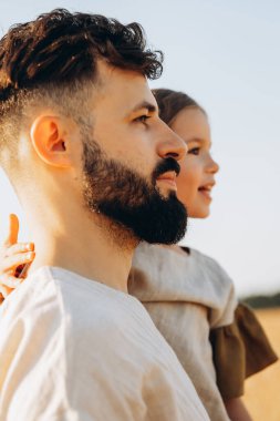 Babasının kollarında tatlı küçük bir kız. Baba ve kızı güneşli bir yaz gününde parkta eğleniyorlar. Babası tarafından tutulan sevimli bir çocuk.