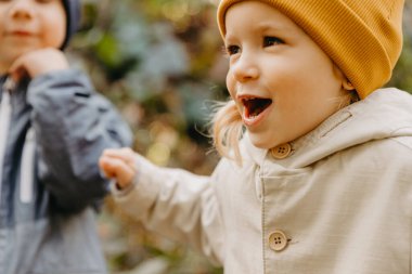 Erkek ve kız kardeş yürüyüşe çıktı: büyük oğlan ve küçük kız birlikte sonbahar parkında yürüyüşe çıktılar. 
