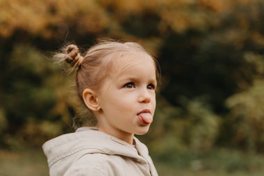 Surat asan bir kızın portresi, sonbahar parkında yürürken farklı duygular gösterir.