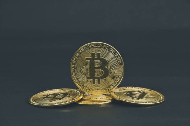 Bitcoin paraları siyah arkaplanda serili.