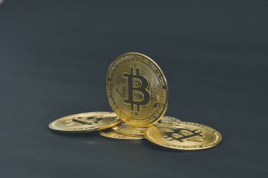 Bitcoin paraları siyah arkaplanda serili.