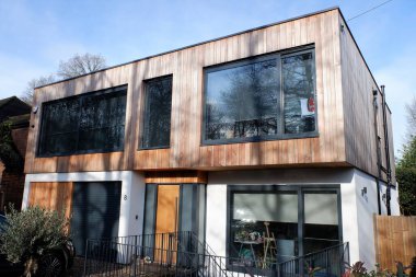 Çağdaş iki katlı düz çatı katı, dış sedir ağacıyla kaplı.