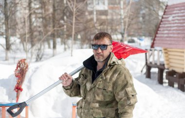 Kar temizleme. Kar temizleme işi çocukların oyun alanında alüminyum saplı kırmızı güçlü bir kürekle sürüklenir..