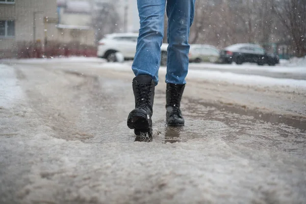 go army boots through puddles in the city, black lace-up boots and wet weather, trekking shoes in the city, rain, snow, and hail in the city it is better to go in reliable shoes.