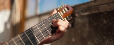 Güneşli bir günde evde gitar çalmak.