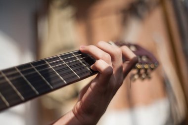 Güneşli bir günde evde gitar çalmak.