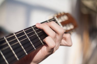 Güneşli bir günde evde gitar çalmak.