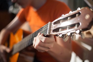 Güneşli bir günde evde gitar çalmak.