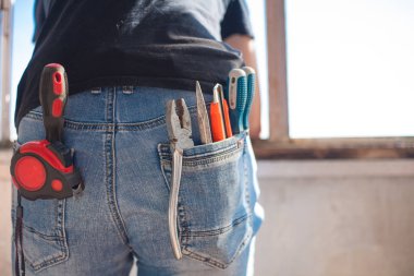 Kot pantolon, mürettebat, kerpeten, bıçak, kerpeten. Arka planda mavi gökyüzü.