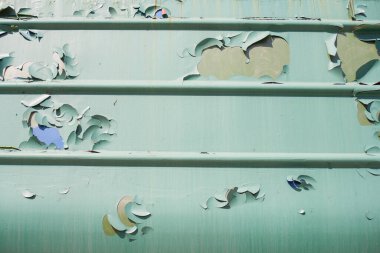Metal yüzeyden yeşil boya soyuluyor.