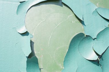 Metal yüzeyden yeşil boya soyuluyor.