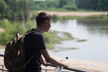 Yazın güneşli ve sıcak bir günde bir adam şehir parkında yürür..