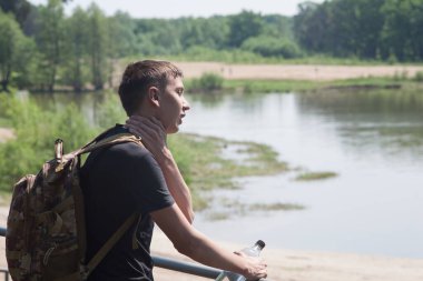Yazın güneşli ve sıcak bir günde bir adam şehir parkında yürür..