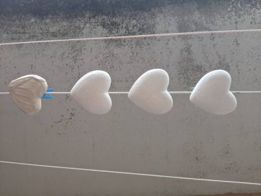 Adamın biri evdeki balkonun pencere eşiğinde otururken oyuncak yapıyor.