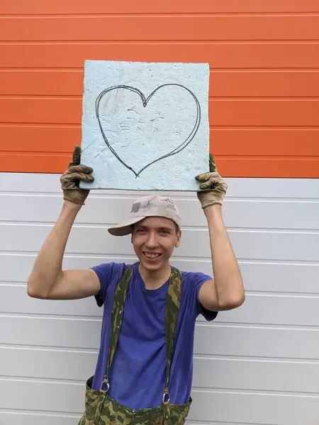 Facet Trzyma Plakat Pomalowanym Sercem Biało Pomarańczowym Tle — Zdjęcie stockowe