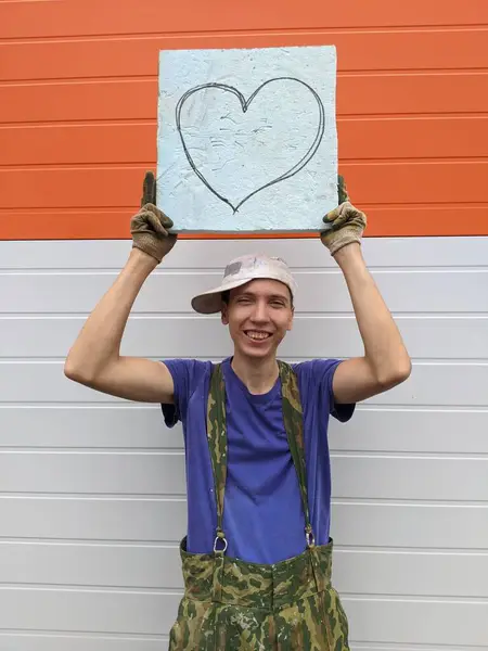 Tipo Sostiene Cartel Con Corazón Pintado Sobre Fondo Blanco Naranja — Foto de Stock