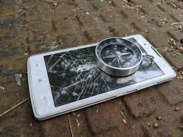 Een Kompas Een Stalen Frame Ligt Een Kapotte Witte Smartphone — Stockfoto