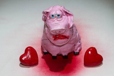 Bir domuz ve bir kalp. Domuz yavrusu pembe, üzgün gözleri ve kırmızı kalpleri var. Sevgililer günü kartı. Sevgililer Günün kutlu olsun..