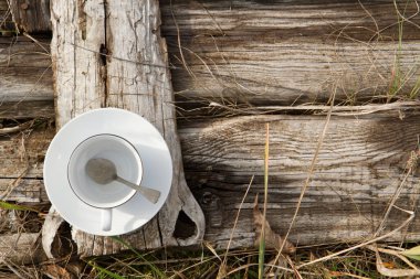Beyaz bir fincan eski bir ahşap masanın üzerinde boş duruyor. Gövde üzerinde beyaz bir fincan eski bir ahşap masada duruyor..