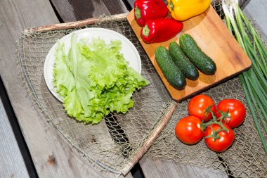 Sebzeler masanın üstünde. Eski çam ağacından yapılmış eski bir masanın üzerinde taze çiğ sebzeler yatıyor..