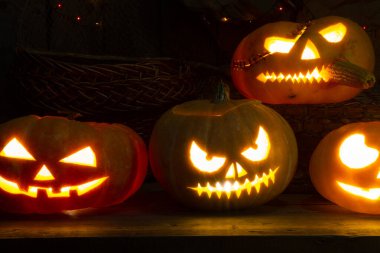 Cadılar Bayramı için yanan çelenkleri olan bir dolabın arka planında balkabağı feneri..