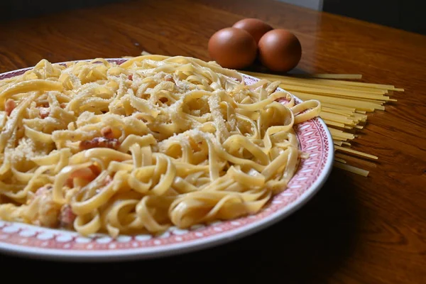 Lezzetli bir tabak rendelenmiş peynirli spagetti. İçinde malzemeler olan bir tabak taze makarna. Makarna ve yumurtalı makarna..