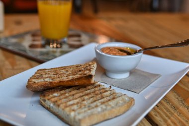 Domatesli kızarmış ekmek. Ezilmiş domatesli tost. Lezzetli kıta kahvaltısı. Domatesli tost, kahve ve portakal suyu..