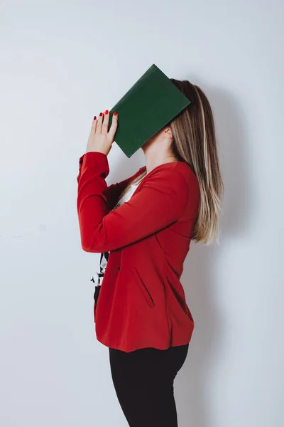 woman with book in front of the face.