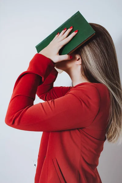 woman with book in front of the face.