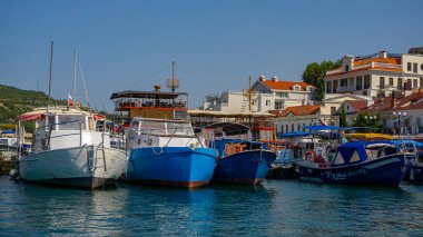 Balaklava seddindeki güzel evlerin arkaplanına karşı rıhtımdaki teknelerin manzarası. Bu tekneler körfez boyunca ve deniz kıyısı boyunca yürümek için. Yüksek hızda değil, ama