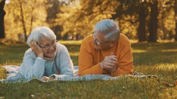 Conceito de bem-estar. Retrato de casal aposentado sênior feliz relaxando no parque de outono — Fotografia de Stock