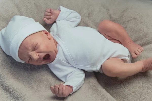 Niedliches Neugeborenes gähnt und dehnt sich auf der Decke — Stockfoto