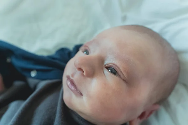 Niedliches Neugeborenes lächelnd in den Händen der Mutter im Krankenhaus — Stockfoto